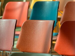 Close-up view of colorful plastic chairs arranged in soft sunlight.