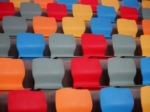 Vibrant plastic stadium seats arranged in colorful, repetitive patterns.